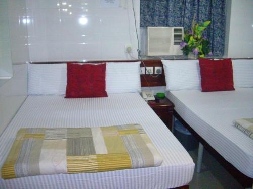 a bedroom with two beds with red and yellow pillows at CANADIAN Hostel in Hong Kong