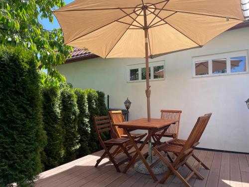 a wooden table with two chairs and an umbrella at SG chaloupka Kubík s wellness v ceně MLÁZOVICE - Český ráj in Mlázovice