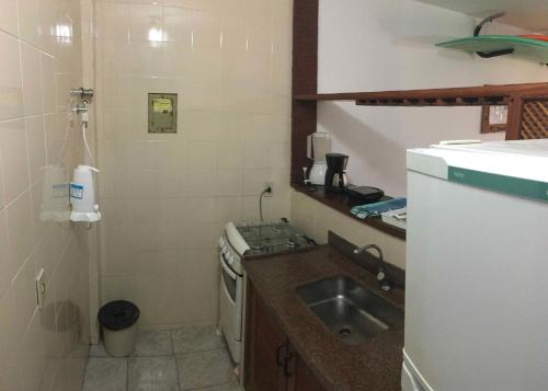 a small kitchen with a sink and a stove at Geribá Shark House in Búzios