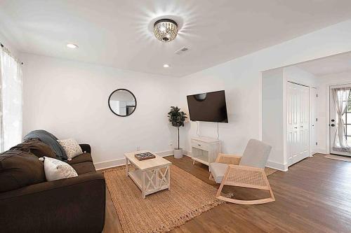 a living room with a couch and a tv at Millcreek Cottage Minutes from Downtown Wilmington in Leland