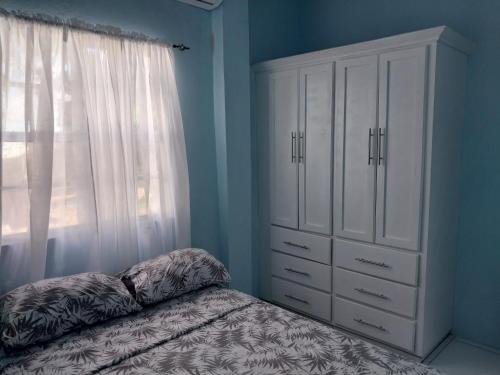 um quarto com uma cama, uma cómoda e uma janela em Avocado Suites em Castries