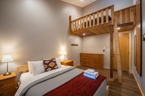 a bedroom with a bunk bed and a staircase at Journey's Perch by Revelstoke Vacations in Revelstoke