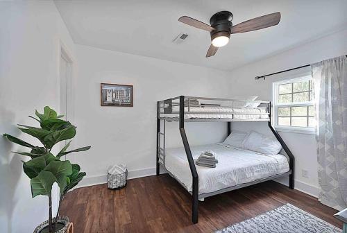 a bedroom with a bunk bed with a ceiling fan at Millcreek Cottage Minutes from Downtown Wilmington in Leland