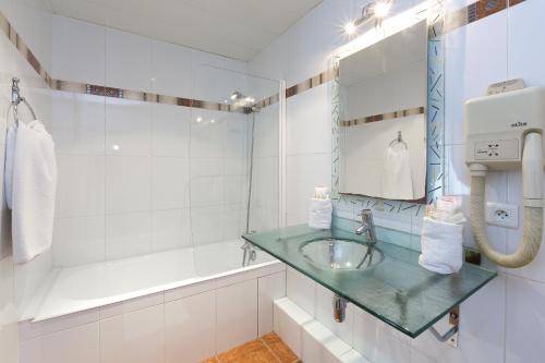 La salle de bains est pourvue d'un lavabo et d'un miroir. dans l'établissement Hotel Viator - Gare de Lyon, à Paris