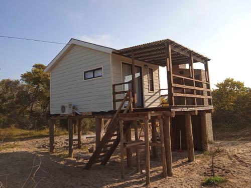 una casa pequeña sentada en una plataforma de madera en Bahía, en Punta del Diablo