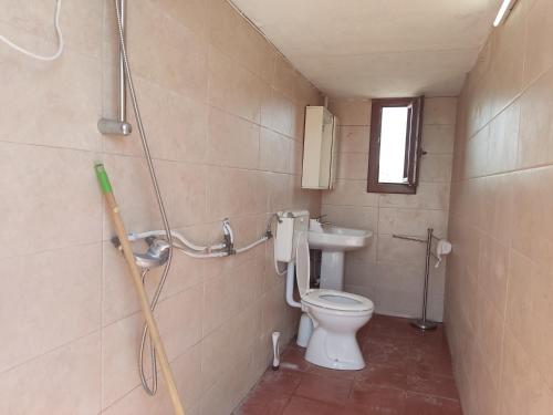 y baño con aseo y lavamanos. en Aree tende presso la casa in campagna di Ottavia, en Alezio
