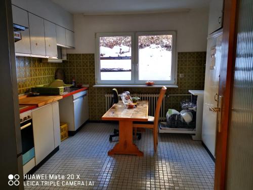 a kitchen with a wooden table and a window at Rosen Garten Haus in Titisee-Neustadt