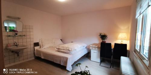 um pequeno quarto com uma cama e um lavatório em Rosen Garten Haus em Titisee-Neustadt