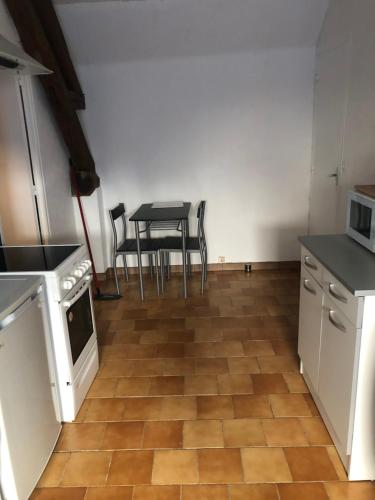 a kitchen with a table and a table and chairs at Appartement 1 chambre in Pouilly-sur-Loire