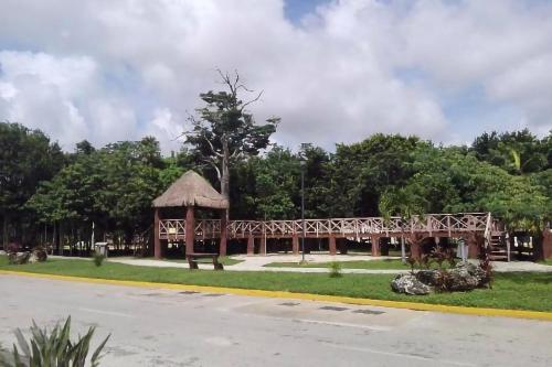 a wooden gazebo with a bridge in a park at Pretty Apartment HOEStel Bacaret! in Cancún