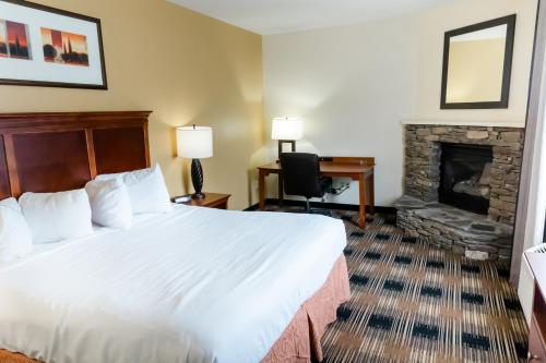 a hotel room with a bed and a fireplace at Country Inn & Suites by Radisson, Helen, GA in Helen