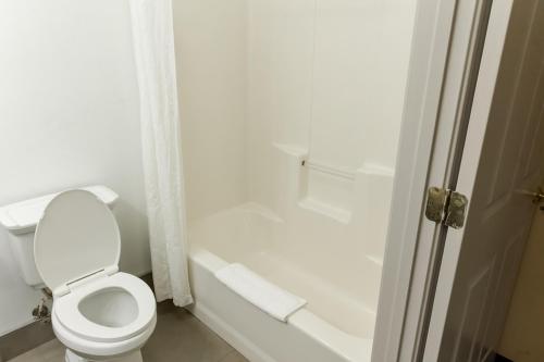 a white bathroom with a toilet and a bath tub at Country Inn & Suites by Radisson, Helen, GA in Helen