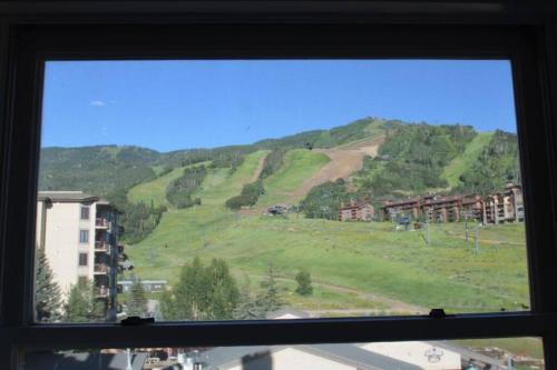 斯廷博特斯普林斯的住宿－True Ski-in Ski-Out Luxury 3bd with huge views，享有绿色山丘景致的窗户