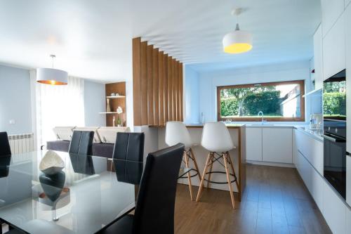 eine Küche und ein Esszimmer mit einem Tisch und Stühlen in der Unterkunft Villa Tavares Suítes in Arouca