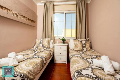 zwei Betten in einem Zimmer mit Fenster in der Unterkunft Tita Apartment Montaña La Data in San Bartolomé de Tirajana