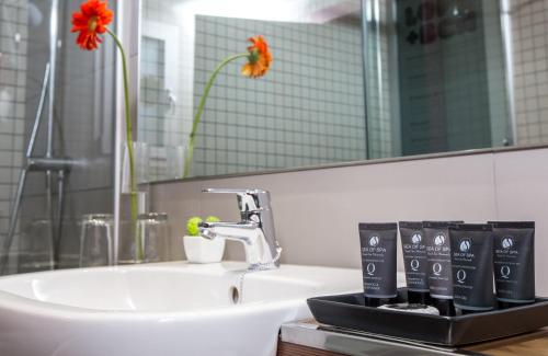 ein Badezimmer mit Waschbecken und Spiegel in der Unterkunft Leonardo Boutique Hotel Barcelona Sagrada Familia in Barcelona