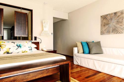 a bedroom with two beds and a couch at Solana Beach Mauritius - Adults Only in Belle Mare