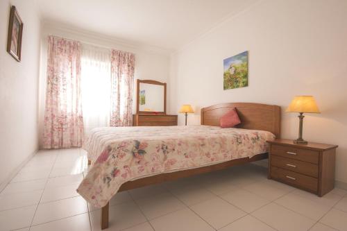 Un dormitorio con una cama grande y una ventana. en Candirocha Mira Sol, en Portimão