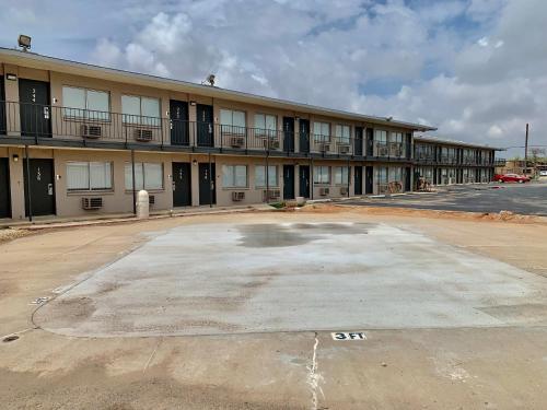 an empty parking lot in front of a building at Rodeway Inn Midland South in Midland