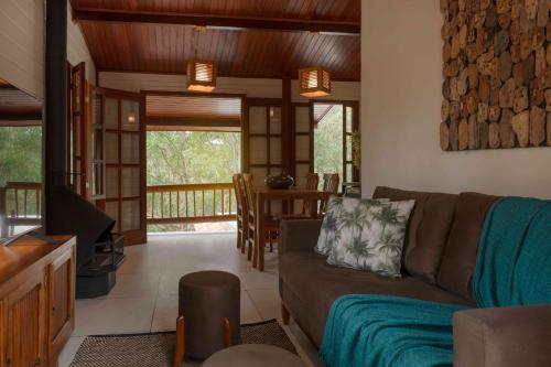 a living room with a couch and a dining room at Embaúba Boutique Hotel in Teresópolis