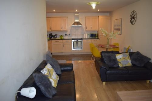 een woonkamer met twee banken en een keuken bij 2 bedroom & 2 bathroom apartment - TcA58 in Watford