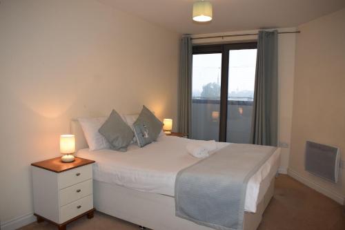 1 dormitorio con 1 cama blanca grande y ventana en 2 bedroom & 2 bathroom apartment - TcA58 en Watford