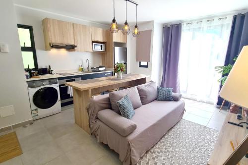 uma sala de estar com um sofá na cozinha em Hitivai apartment em Papeete