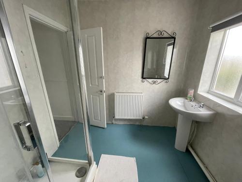 a bathroom with a sink and a shower and a mirror at Golden Triangle Rooms in Norwich