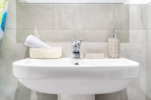 a white bathroom sink with a faucet and towels at Dunstan House Luxury Holiday Home with free parking in Oxford