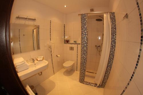 a bathroom with a shower and a toilet and a sink at Hotel Kosmonauty Wrocław-Airport in Wrocław