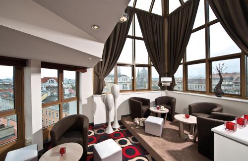 a restaurant with large windows and tables and chairs at Leonardo Hotel Vienna in Vienna