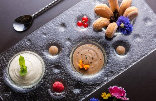 a plate of food with dip and berries and flowers at Leonardo Royal Hotel Venice Mestre in Mestre