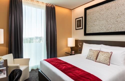a hotel room with a bed and a large window at Leonardo Royal Hotel Venice Mestre in Mestre