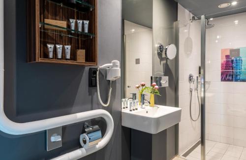 La salle de bains est pourvue d'un lavabo et d'une douche. dans l'établissement NYX Hotel Prague by Leonardo Hotels, à Prague