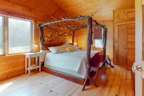 ein Schlafzimmer mit einem Bett in einer Holzhütte in der Unterkunft Kismet in North Hero