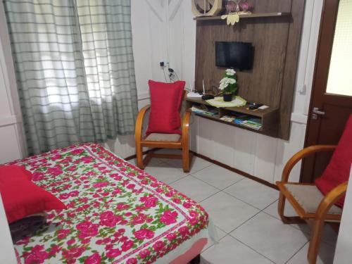 a room with a bed and two chairs and a desk at Sitio Paraiso Central - Casa Branca in Rodeio