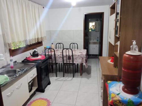 een keuken en eetkamer met een tafel en stoelen bij Sitio Paraiso Central - Casa Branca in Rodeio