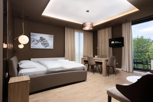 a bedroom with a bed and a table with chairs at Hill Apartments in Požarevac