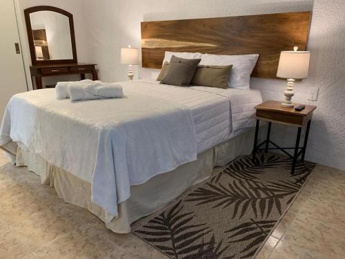 a bedroom with a large white bed and a mirror at Hotel Posada Santa Fe in Guadalajara