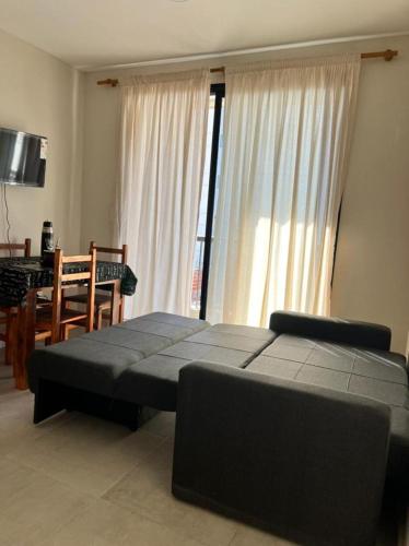 1 dormitorio con 1 cama y comedor con mesa en Apart Juncal en Corrientes