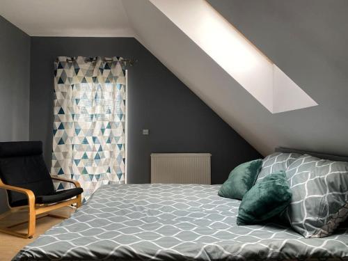 a bedroom with a bed and a window and a chair at 4 Bedroom family house with access to a hot tub in Goczałkowice-Zdrój