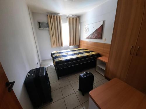 um pequeno quarto com uma cama e duas bagagens em Thermas Paradise Apart em Rio Quente