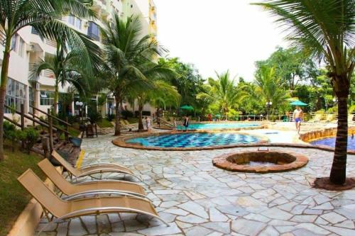 um resort com piscina e palmeiras em Thermas Paradise Apart em Rio Quente