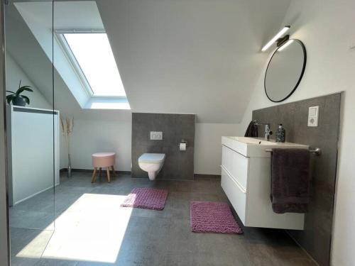 ein Badezimmer mit einem WC, einem Waschbecken und einem Spiegel in der Unterkunft Studio - Apartment Steinmetz mit Balkon in Reken