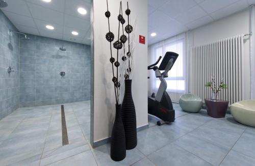 a bathroom with a treadmill and a walk in shower at Leonardo Hotel Völklingen-Saarbrücken in Völklingen