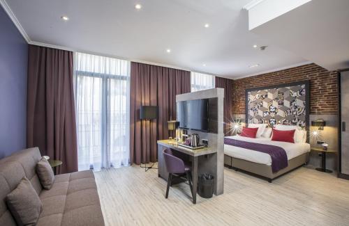 バルセロナにあるレオナルド ホテル バルセロナ ラス ランブラスのベッドとテレビが備わるホテルルームです。