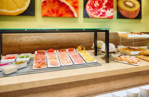 a display case with many different types of pastries at Leonardo Hotel Munich City South in Munich