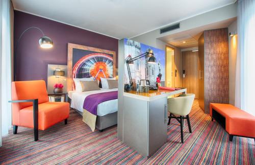 una camera d'albergo con letto e scrivania di Leonardo Hotel Munich City South a Monaco