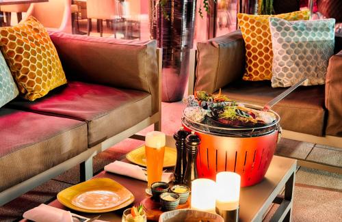a restaurant with a table with a pot of food on it at Leonardo Hotel Munich City South in Munich