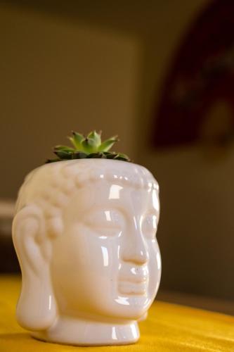 a white vase with a plant in it on a table at Hotel Boutique Mardeka in Orizaba